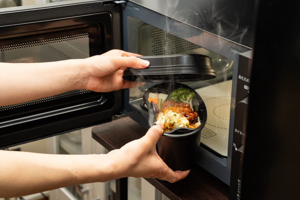 「飯ごう」モチーフのテイクアウト容器をレンジアップ使用したイメージ